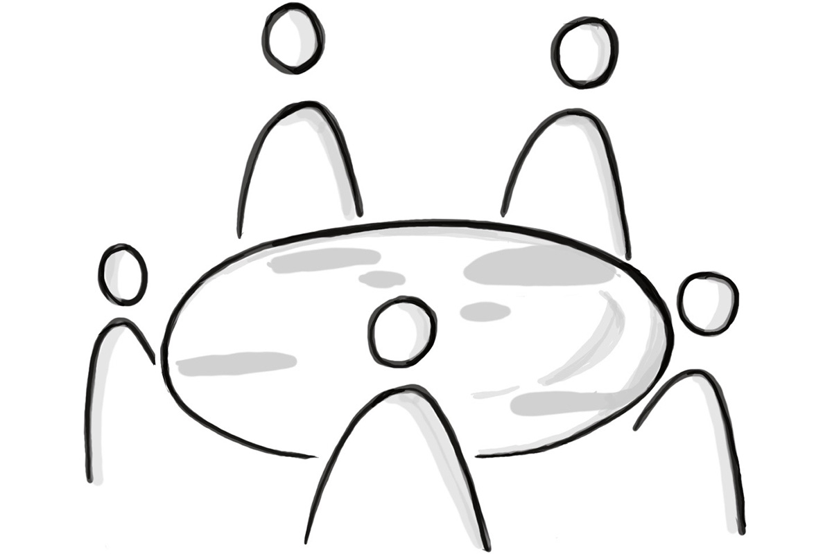 Fünf Personen sitzen um einen runden Tisch, symbolisieren Teamarbeit